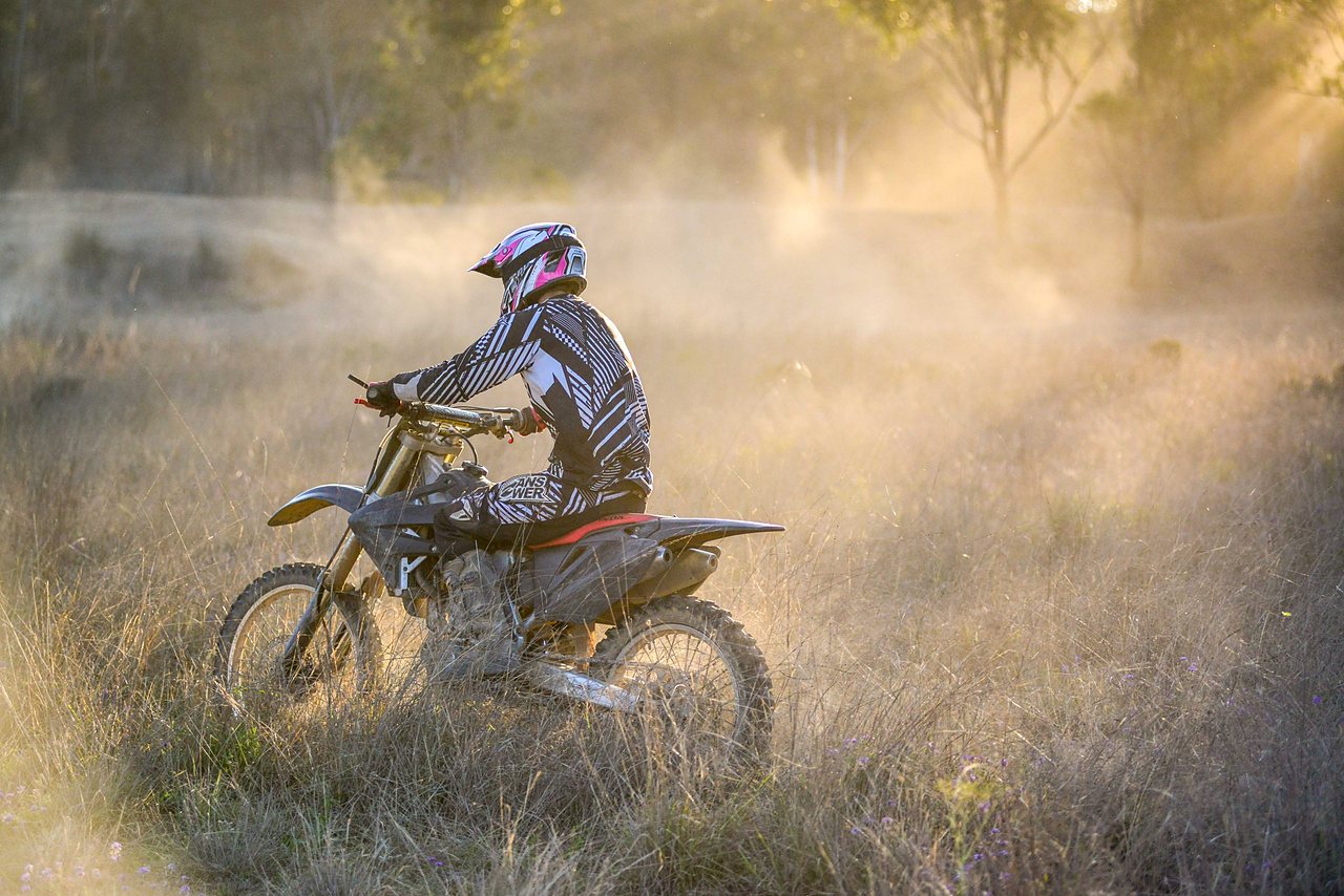 Motorbike rider kicking up dust on the trail