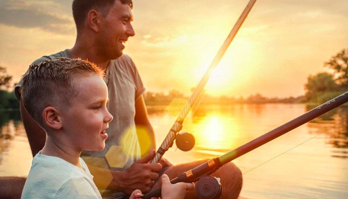 Father and son fishing at sunset
